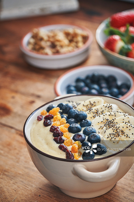 碗中的香蕉奶昔，上面放有蓝莓、香蕉、蔓越莓和超级食品图片素材