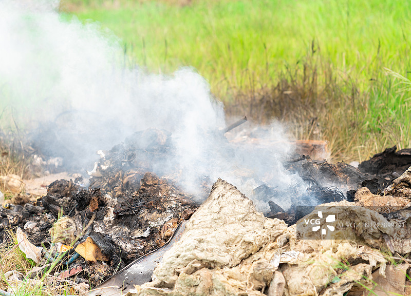 一堆垃圾正在燃烧，产生烟雾，泰国图片素材