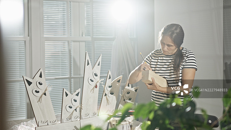 木匠在工作室里制作工艺品，猫雕塑图片素材