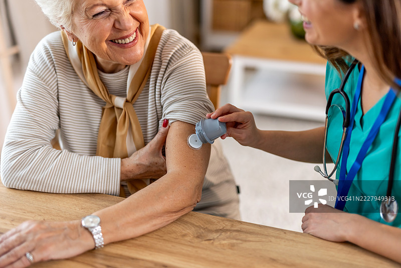 微笑着的老年女性在护士的照顾下接受医疗服务图片素材