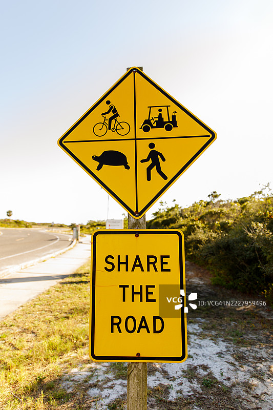 “共享道路”标志位于亨德森海滩州立公园入口，提醒游客骑自行车、行人、高尔夫球车和海龟也使用道路。图片素材