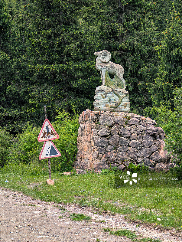 吉尔吉斯斯坦天山上的马可波罗羊雕像和落石警告标志图片素材