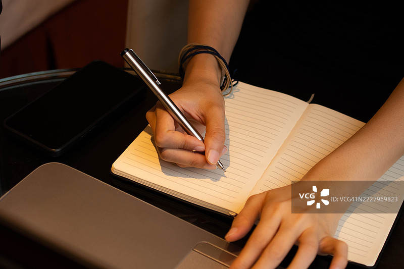 一位中年千禧一代的东南亚女性在家中使用笔记本电脑——通过用户友好的应用程序和平台检查余额、进行交易和管理预算。图片素材