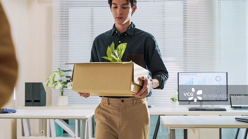 压力大的商人被解雇，手提个人物品的箱子，辞职、裁员和离开办公室。图片素材