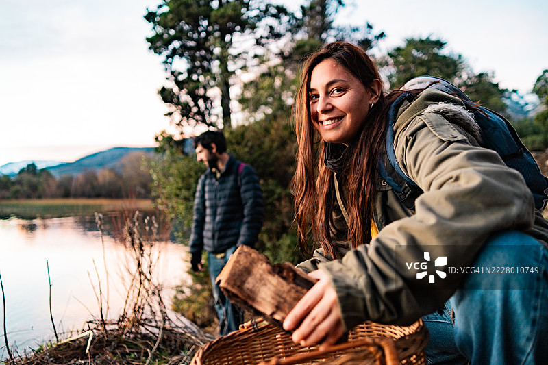 一位中年女性在阿根廷巴塔哥尼亚捡拾掉落的树枝以生火图片素材