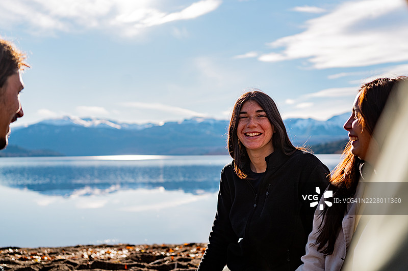 在阿根廷巴塔哥尼亚，一位年轻女性与朋友们围坐在一起的肖像。图片素材