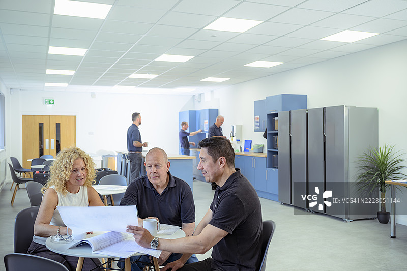 工人在工厂餐厅研究图纸图片素材