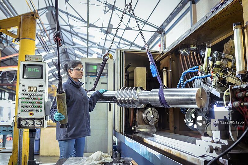 工程师在工程工厂中操作大型切割钢制蜗轮图片素材