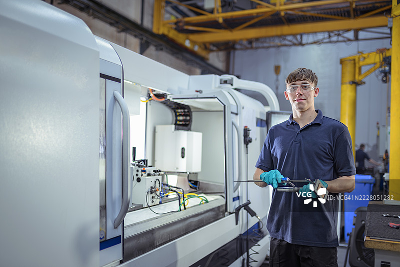 工程师在工程厂使用数控车床测量零件图片素材