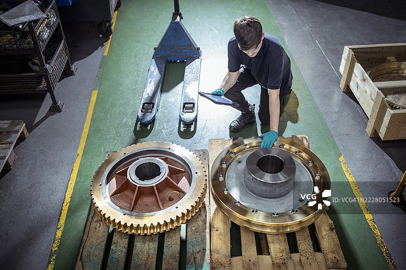 工程师在工程工厂检查黄铜齿轮图片素材