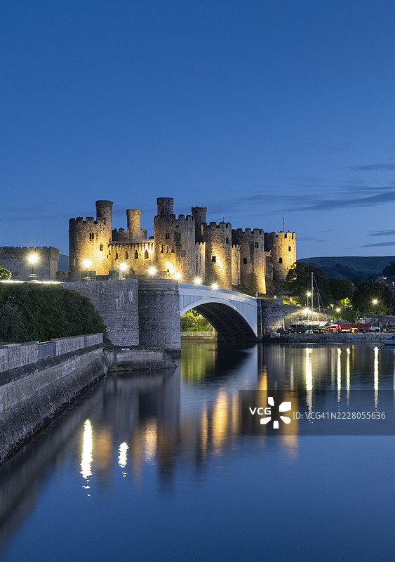 威尔士康威，英国 - 2024年6月6日：夜晚从康威河和康威河口远眺联合国教科文组织世界遗产康威城堡，康威，康威县，北威尔士，英国图片素材