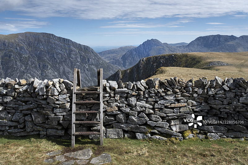 在英国北威尔士埃里里国家公园的卡尔内德·菲利亚斯特山上，奥格温谷上方的风格与干石墙图片素材