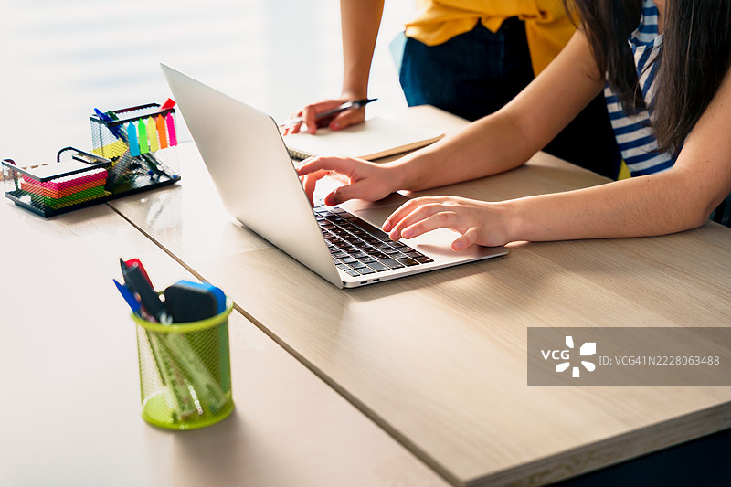 拉丁美洲的千禧一代和Z世代女性正在使用笔记本电脑合作项目。图片素材