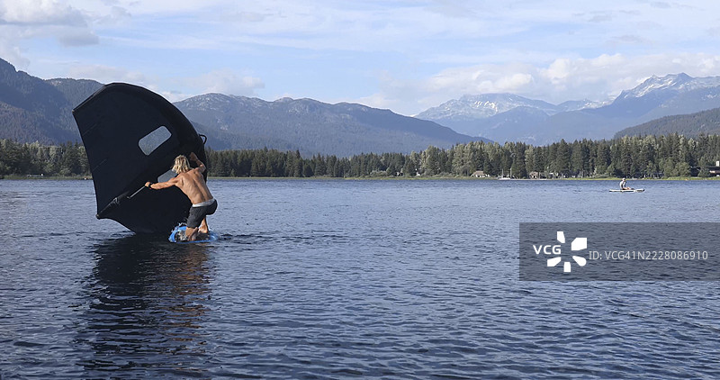 年轻男子在惠斯勒湖上进行翼板运动图片素材
