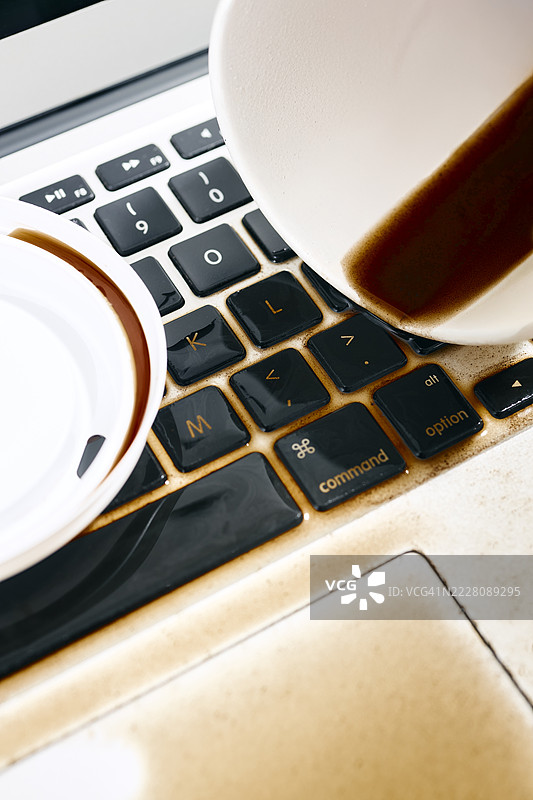 笔记本电脑上洒出的咖啡特写图片素材