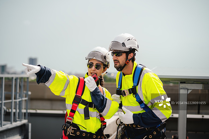 工程师和技术人员正在检查工厂屋顶太阳能电池板的安装，可再生能源，清洁能源图片素材