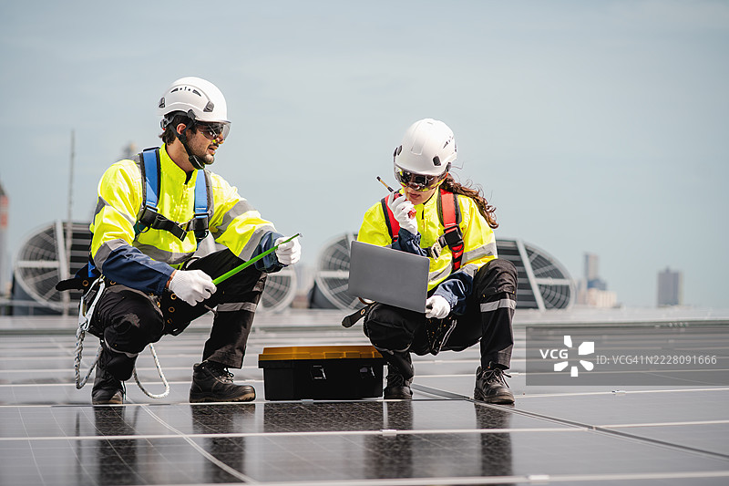 工程师和技术人员正在检查工厂屋顶太阳能电池板的安装，可再生能源，清洁能源图片素材