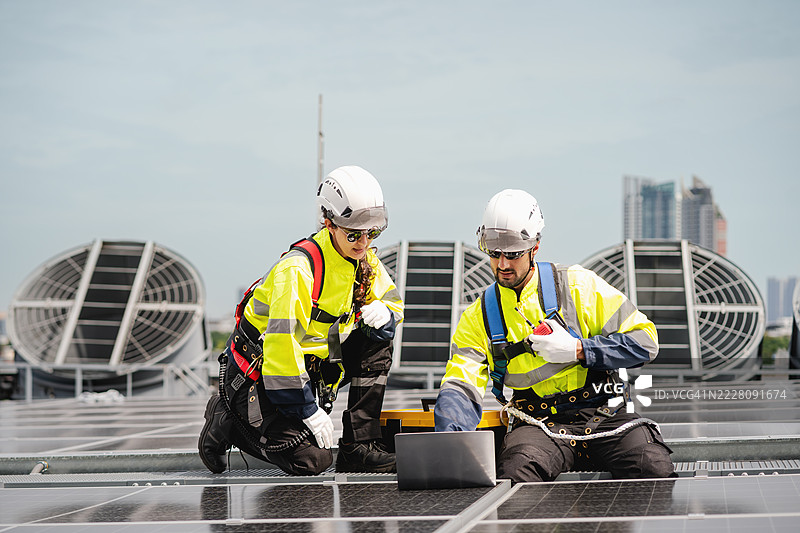 工程师和技术人员正在检查工厂屋顶太阳能电池板的安装，可再生能源，清洁能源图片素材