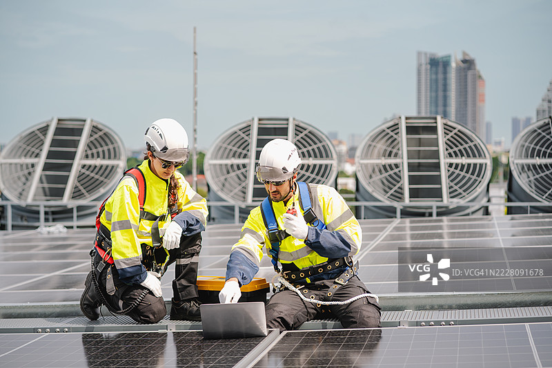 工程师和技术人员正在检查工厂屋顶太阳能电池板的安装，可再生能源，清洁能源图片素材