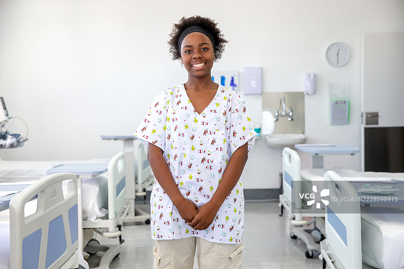 微笑女孩在病房里穿着医院睡衣的肖像图片素材