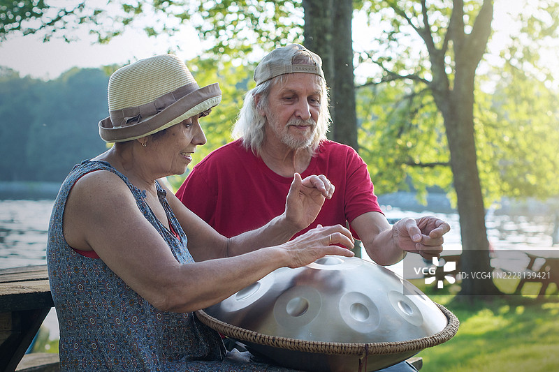 退休人员练习手碟音乐。老年夫妇在波科诺山湖泊度假村享受音乐爱好。图片素材