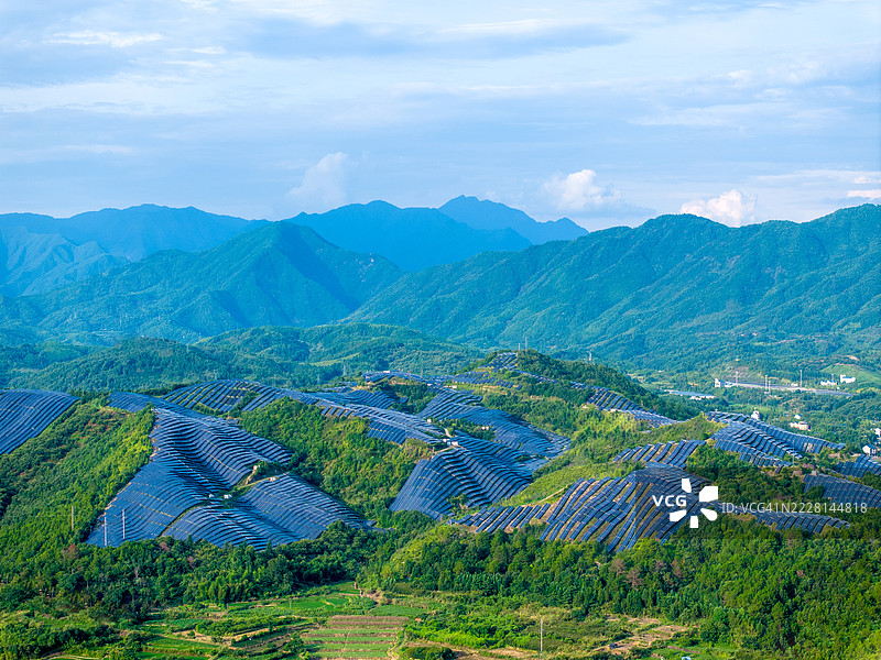 日落时分山上的太阳能发电厂的鸟瞰图图片素材