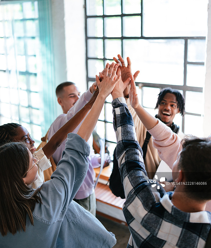 一群朋友在明亮的房间里欢笑和欢呼图片素材
