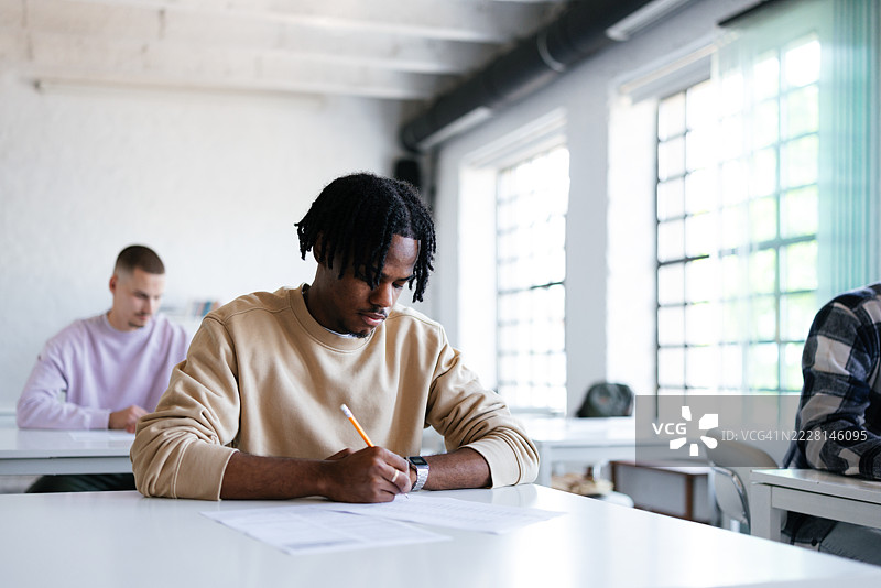 学生们在明亮的教室里专注于教育考试。图片素材