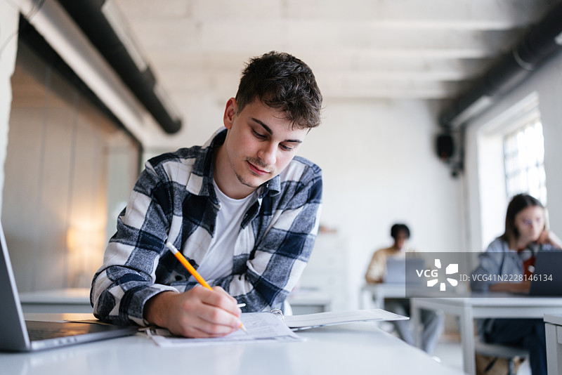 学生在教室环境中专注地做作业图片素材