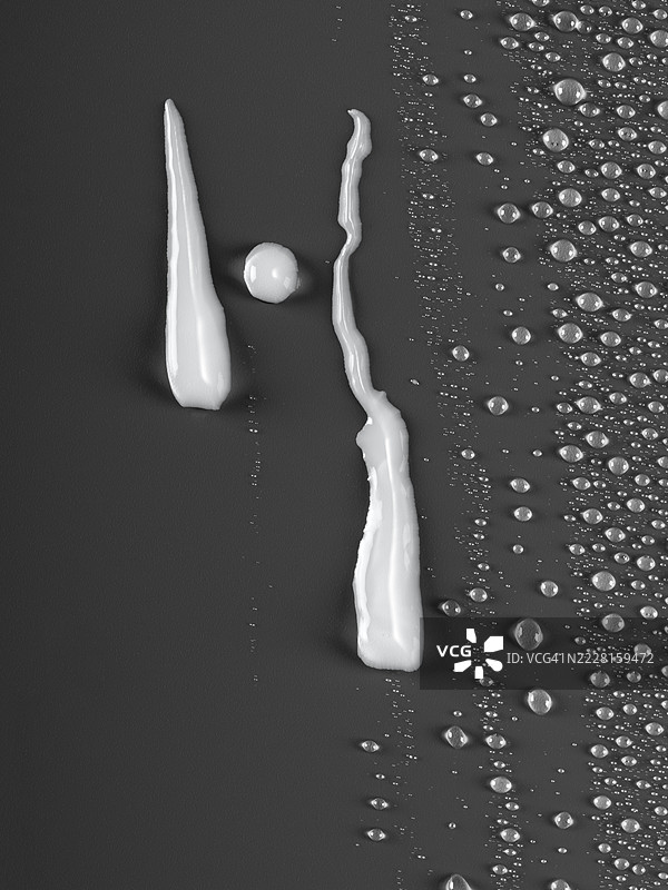 牛奶滴落在湿润的水珠表面上。图片素材