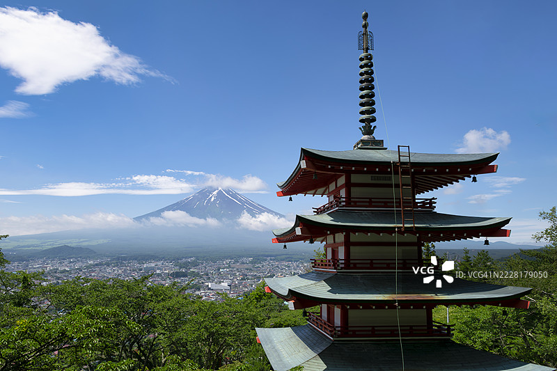 夏季富士山与郁郁葱葱的塔楼和绿叶相映成趣图片素材