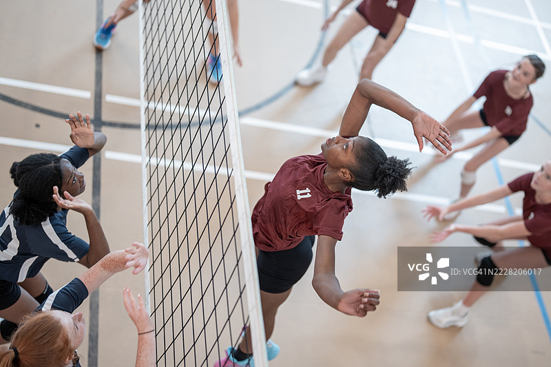 女子排球队在体育馆比赛中专注于运动表现图片素材