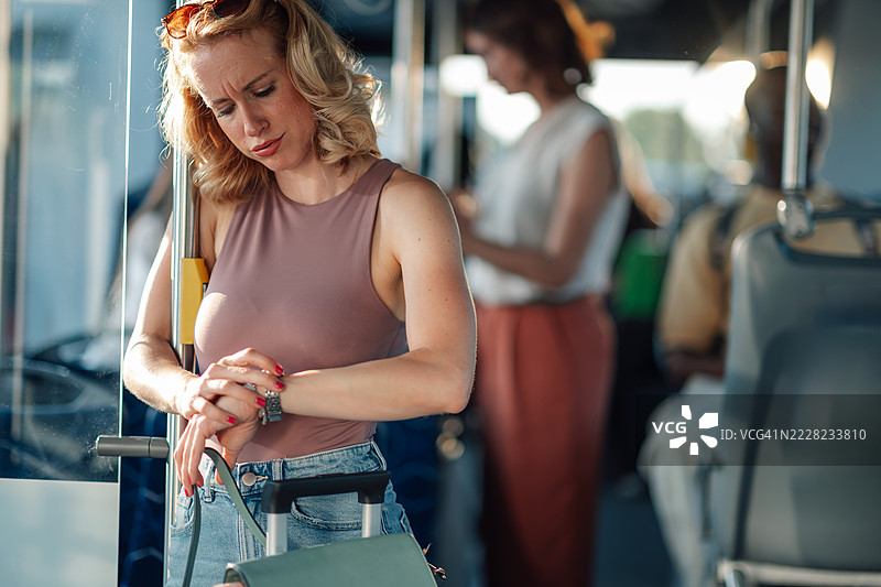 不耐烦的游客在公交车上查看时间图片素材