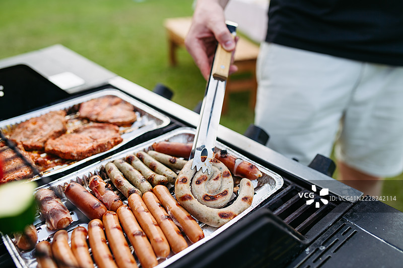 混合香肠和肉类在烧烤上烤制的特写镜头图片素材