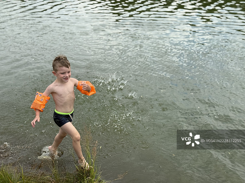 小男孩在湖面上奔跑图片素材