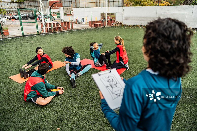 男女球员在足球比赛前一起拉伸图片素材
