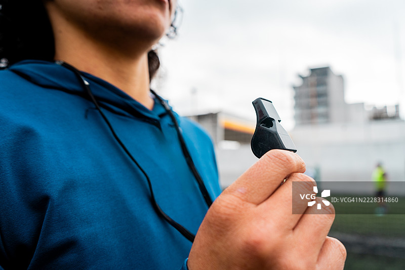 女教练在球场上吹哨的特写镜头图片素材