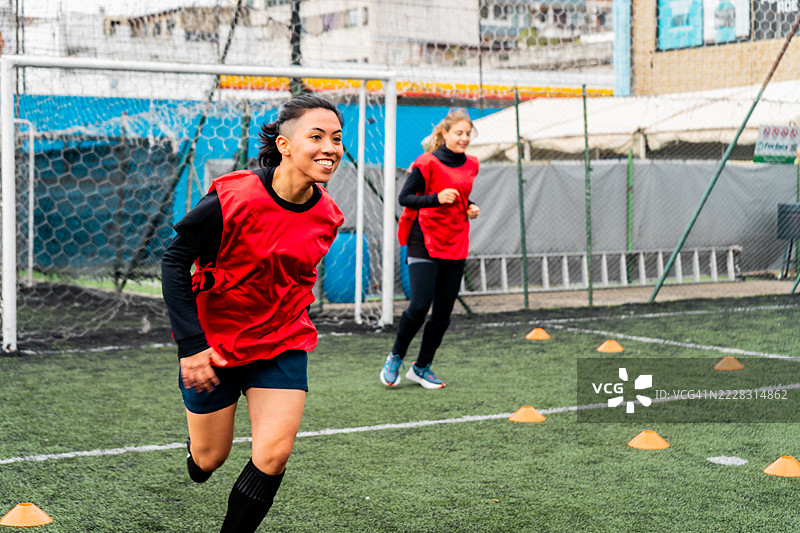 女足球运动员在场上练习技能。图片素材
