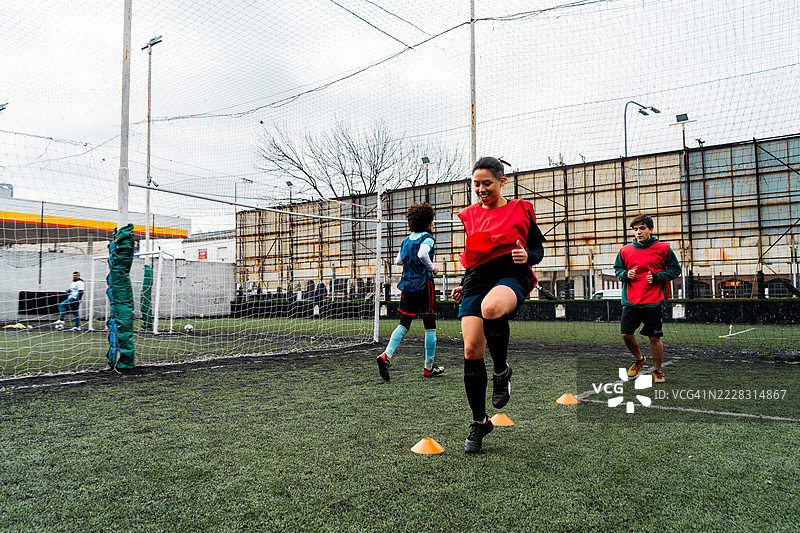 男女足球运动员在场上练习技能。图片素材