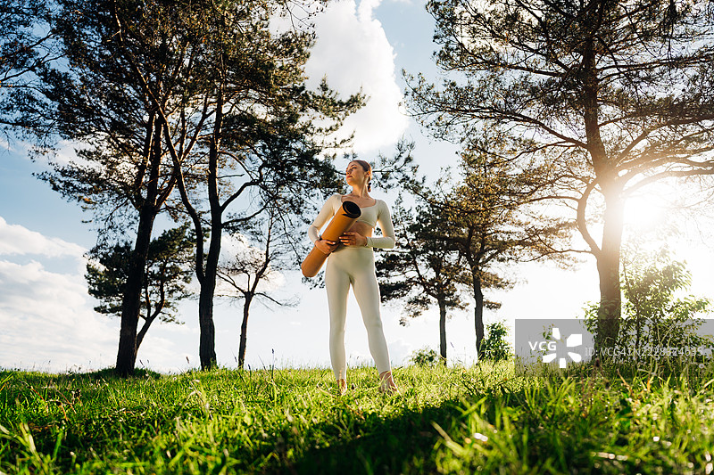 年轻女性为户外瑜伽做准备图片素材