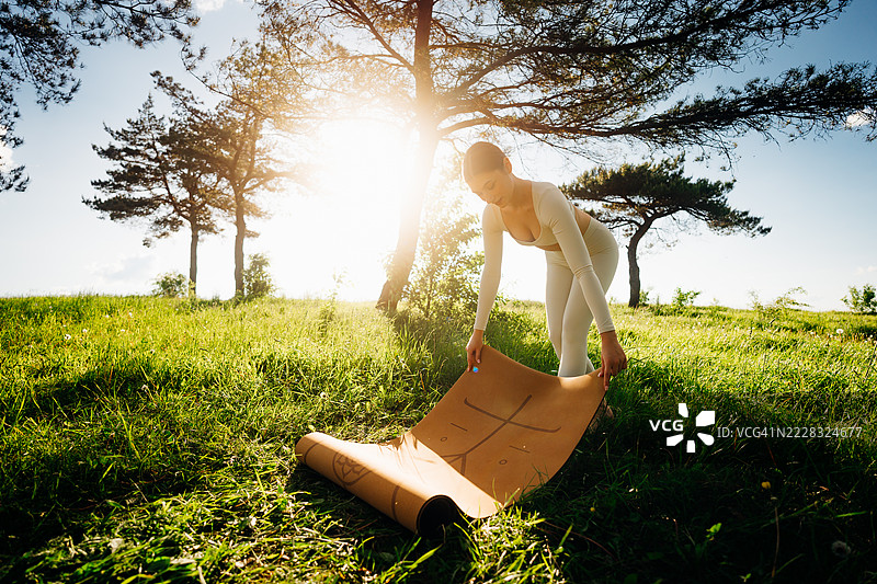年轻女性为户外瑜伽做准备图片素材