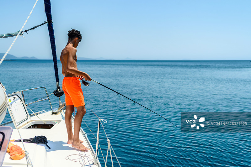年轻男子在船上钓鱼图片素材