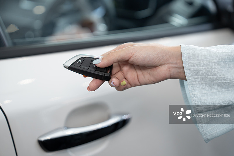 女性手用电子车钥匙解锁汽车图片素材