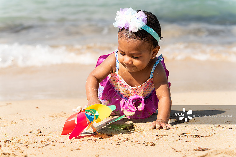 小女孩在海滩上玩风车图片素材