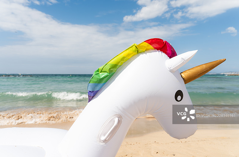 沙滩上的充气独角兽浮筒图片素材