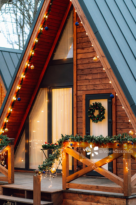 温馨的A框小屋装饰着圣诞灯光和饰品图片素材