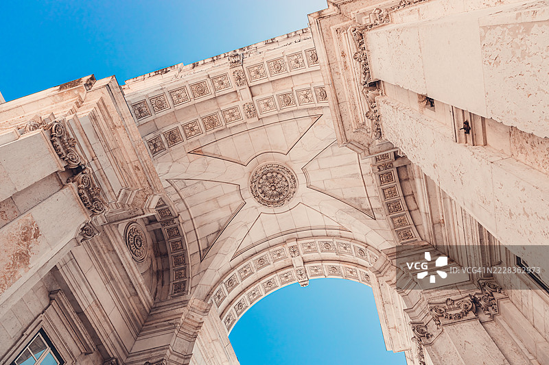 里斯本的奥古斯塔街拱门，一座宏伟的新古典主义凯旋门，低角度视图映衬蓝天图片素材