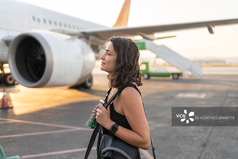 女性游客在飞机前走向飞机，准备登机开始她的假期图片素材