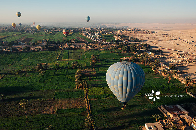 沙漠和绿洲山谷地平线上热气球。旅行。乘坐热气球飞行。埃及卢克索。图片素材