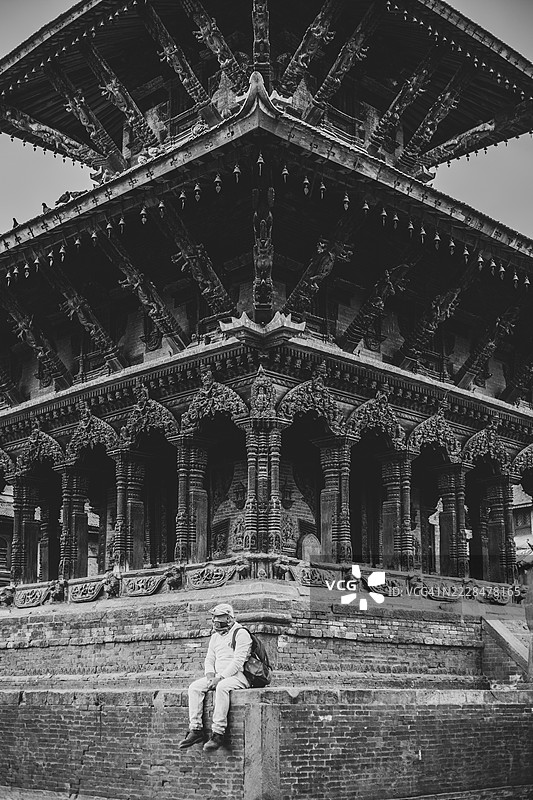 一个人在尼泊尔加德满都的帕坦杜巴广场新ar建筑外坐着。图片素材